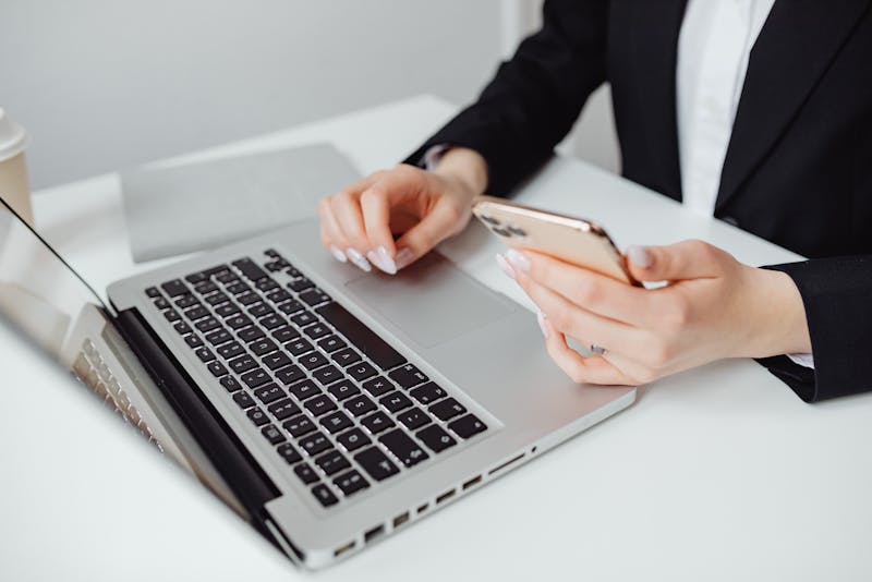 a woman wearing a blazer working on her laptop